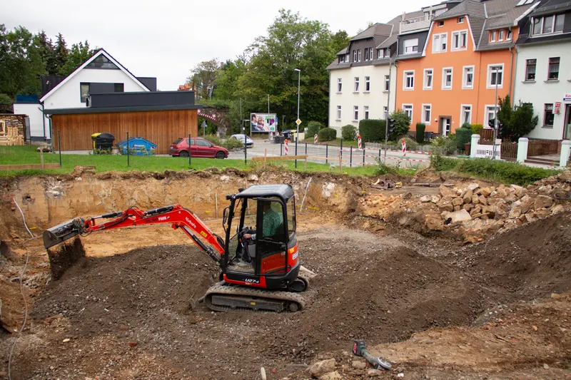 Minibagger ebnet die Sohle der Baugrube ein