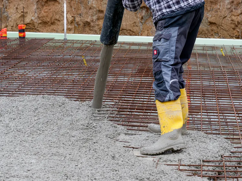 Beton wird über den Pumpenschlauch auf die Bewehrung der Bodenplatte gegeben