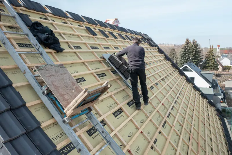 Dachdecker beim Eindecken des Dachs auf der Aufsparrendämmung