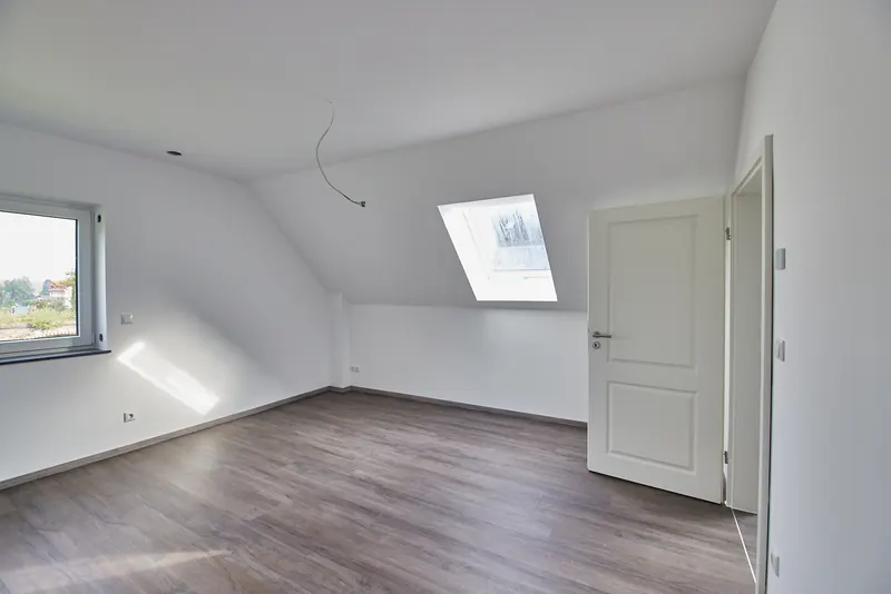 Fertiges Zimmer im Dachgeschoss mit Dachfenster