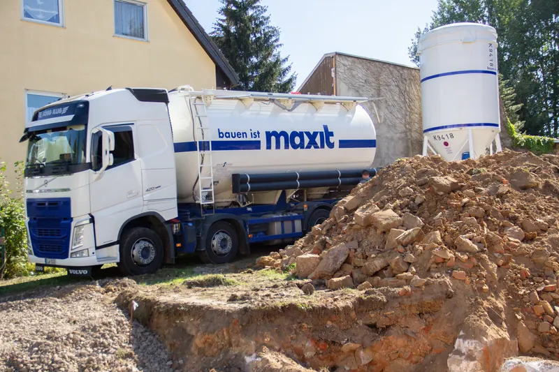 Einblasfahrzeug von maxit füllt das Silo auf der Baustelle mit neuer Trockenmischung auf
