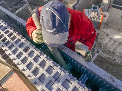 Beton wird mit dem Pumpenschlauch von oben in die isorast-Wand gefüllt