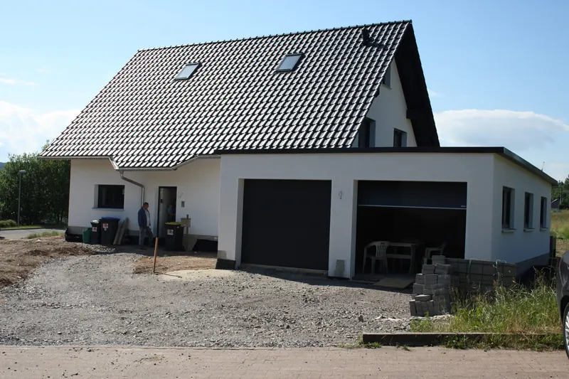 Einfamilienhaus mit angebauter Doppelgarage kurz nach Fertigstellung