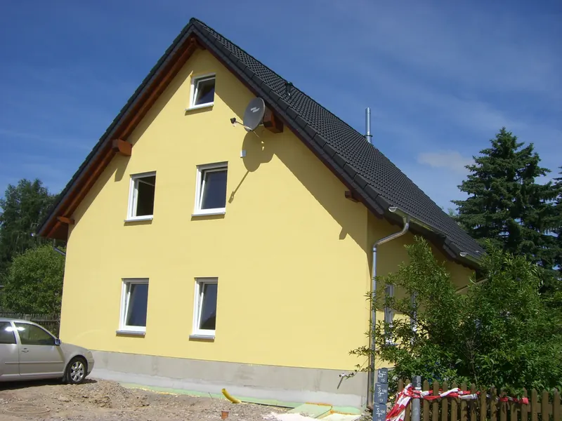 Gelbes Einfamilienhaus mit steilem Satteldach