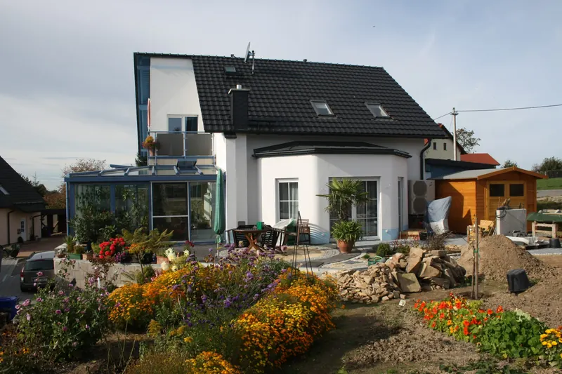 Einfamilienhaus mit Wintergarten und bepflanztem Vorgarten