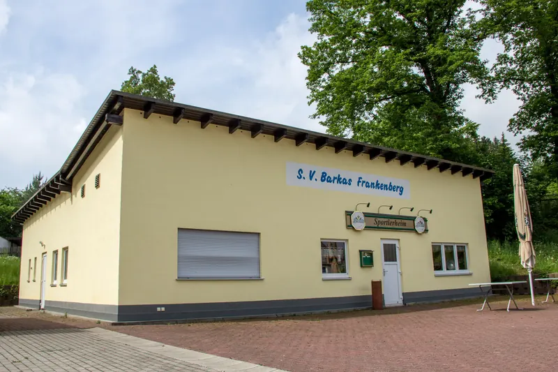 Gelbes Vereinsgebäude mit Satteldach und Vereinsschild